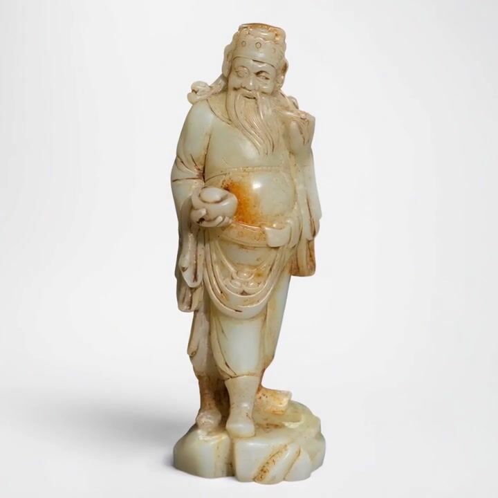 Film of A Substantial Ming Dynasty Pale Celadon and Russet Nephrite Jade Figural Carving of an Immortal
